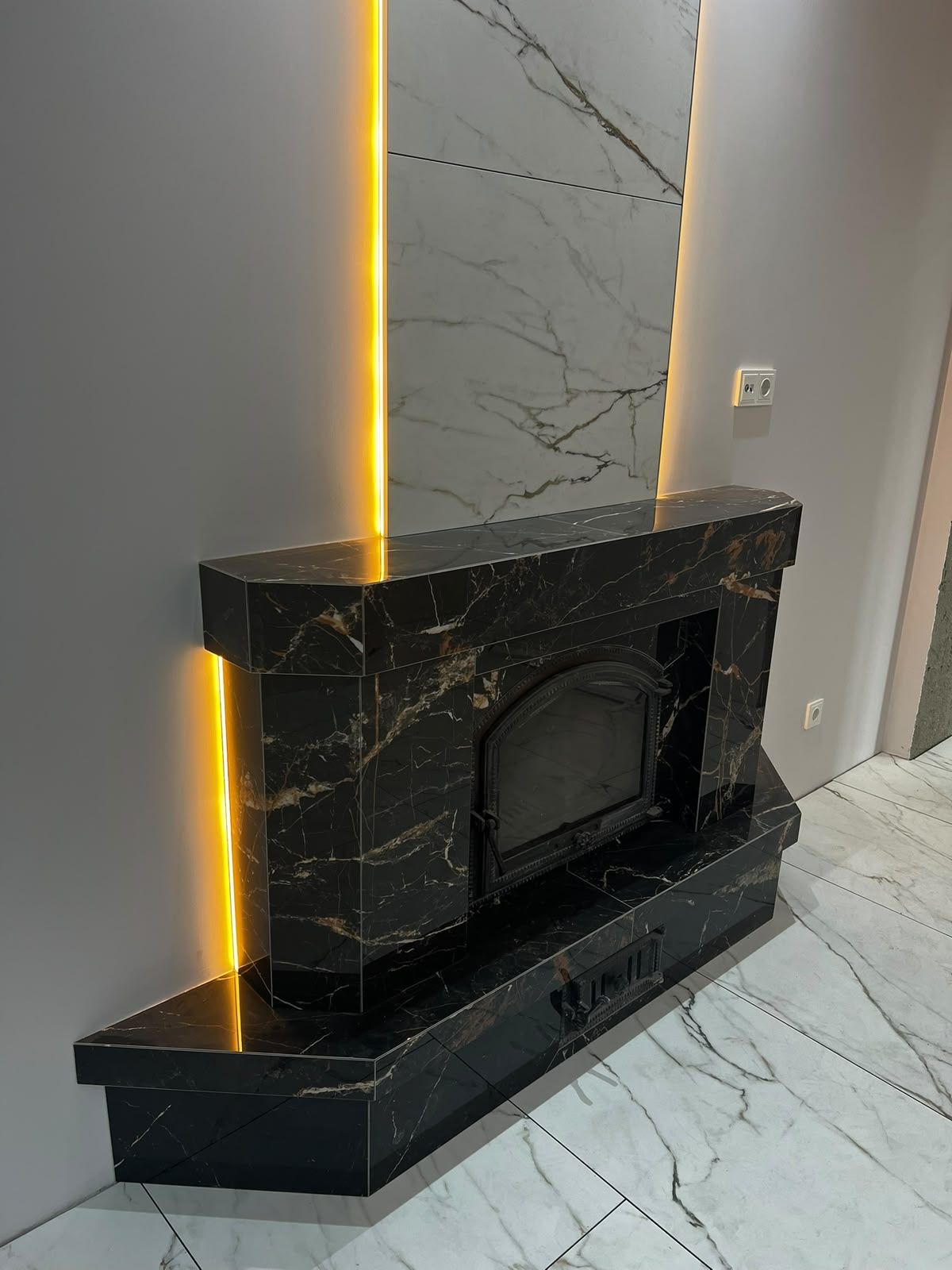 Cheminée habillée de marbre noir veiné d'or