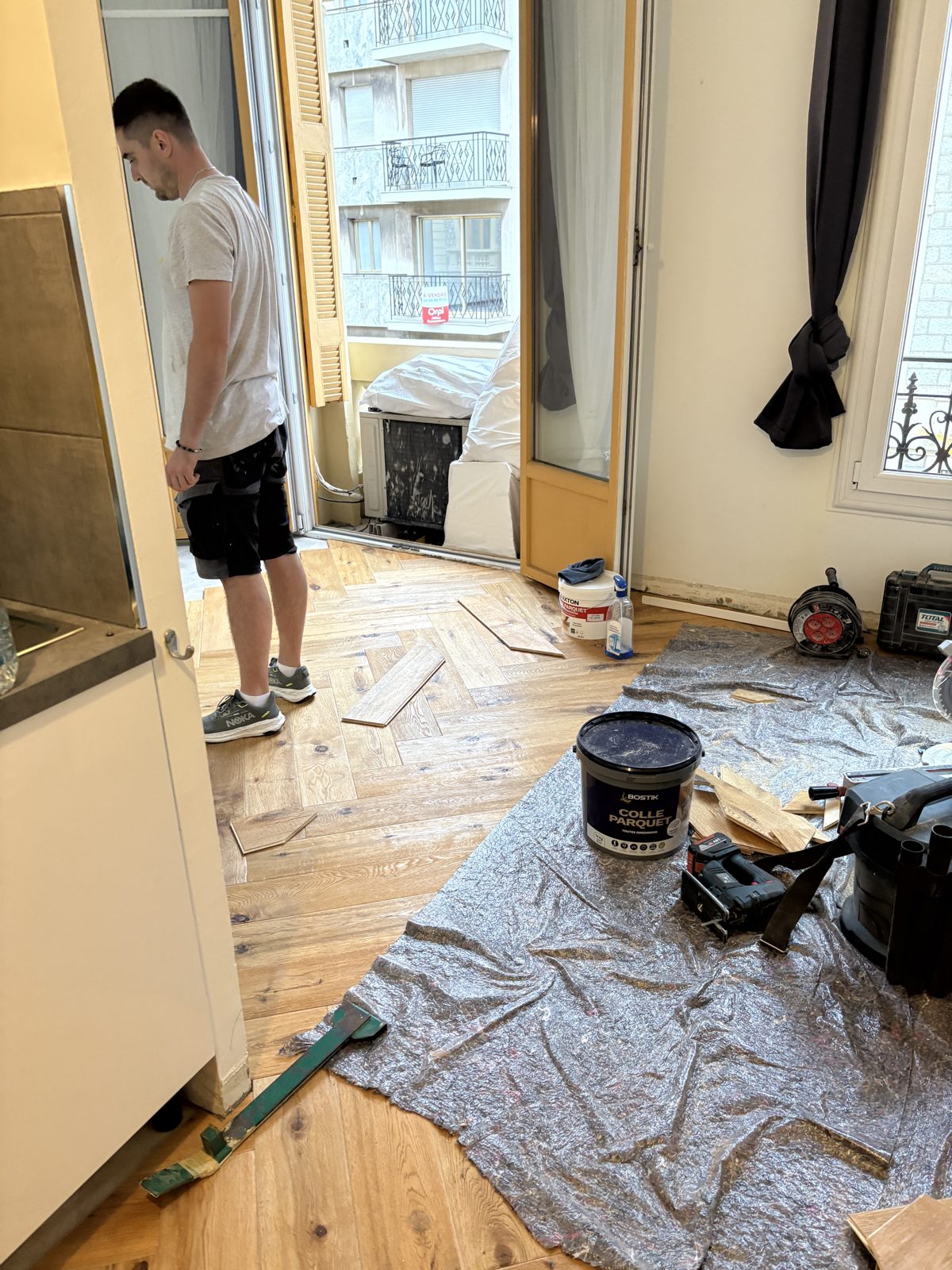 Pose collée d'un parquet en bâtons rompus, sol protégé pendant le chantier