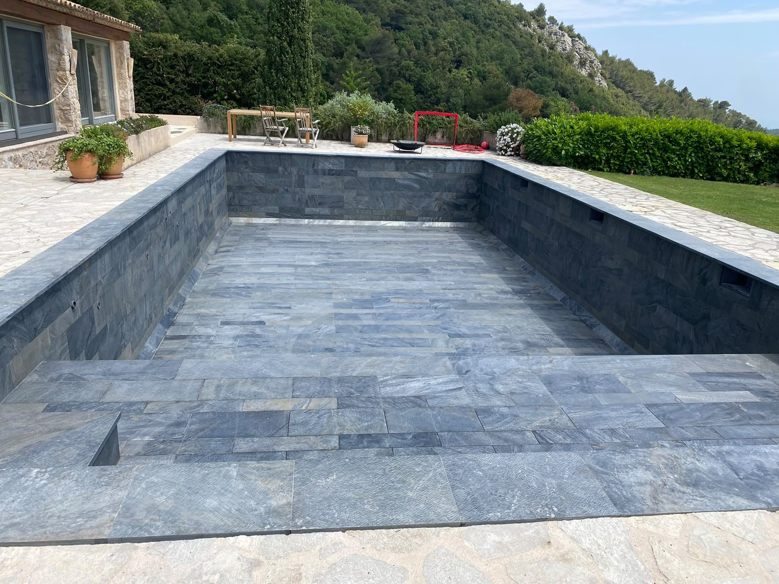 Bassin de piscine revêtu de pierre naturelle grise