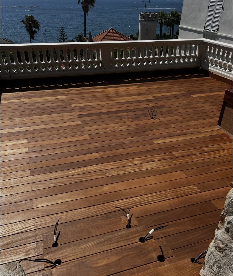 Terrasse en bois exotique sur un toit-terrasse avec vue sur la mer